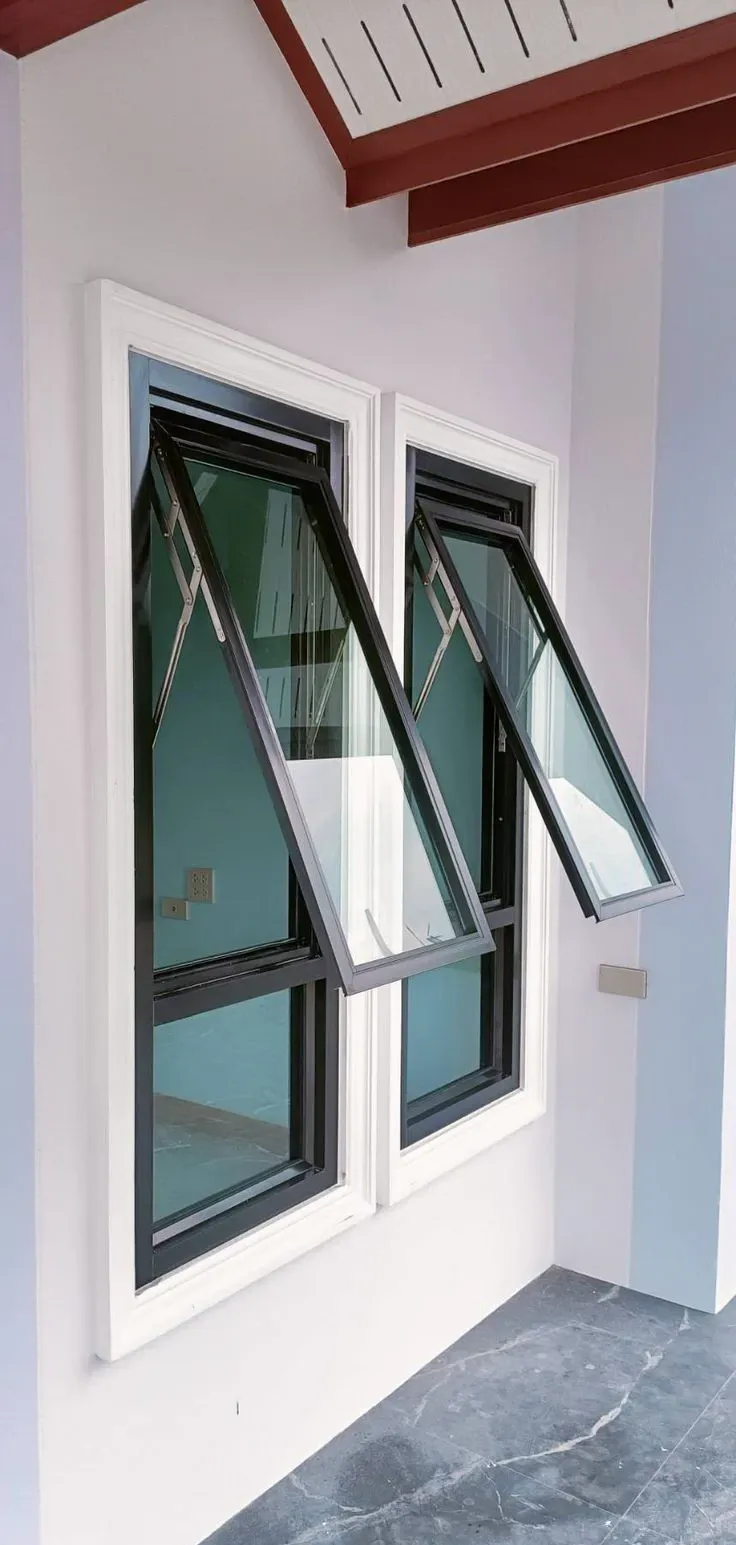 Duas janelas maxim-ar de alumínio preto abertas, com vidro verde e acabamento branco ao redor